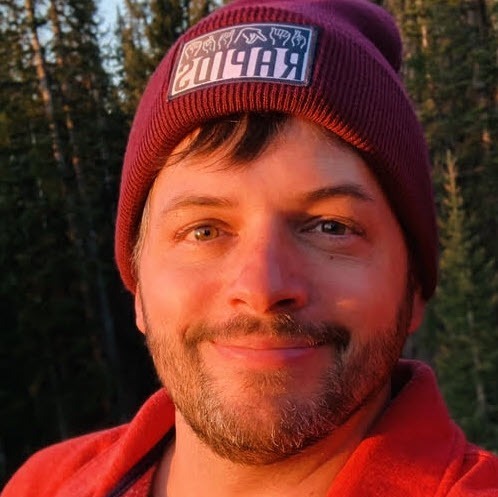 Luke Adams - a person wearing a winter hat smiles at the camera