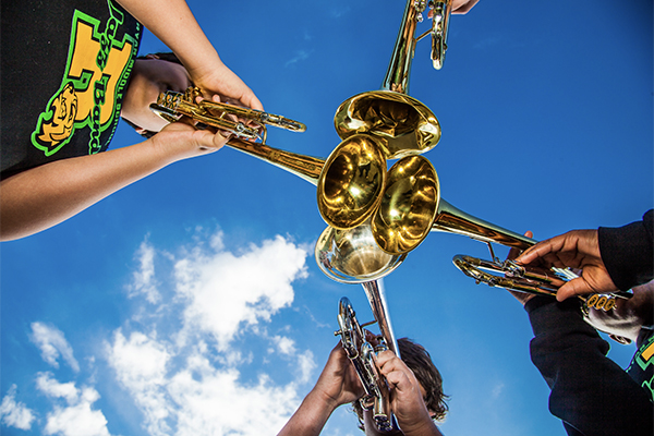 Three trumpets from below under a blue sky
