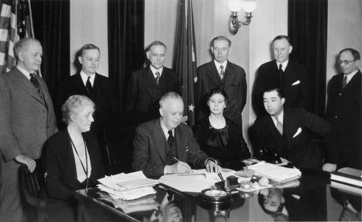 Alaska Governor John Troy signed the bill that changed the Alaska Agricultural College and School of Mines to the University of Alaska. Signing of Bill No. 97. Standing from left to right: James Wickersham, Charles Bunnell, Senate President Luther Hess, Reps./Regents Andrew Nerland and Arthur A Shonbeck, and Speaker of the House J.S. Hofman. Seated: Regent Grace Wickersham, Governor Troy, Regent Harriet Hess, and Rep. George Lingo. Photo: UAF Rasmuson Library, Charles Bunnell Collection
