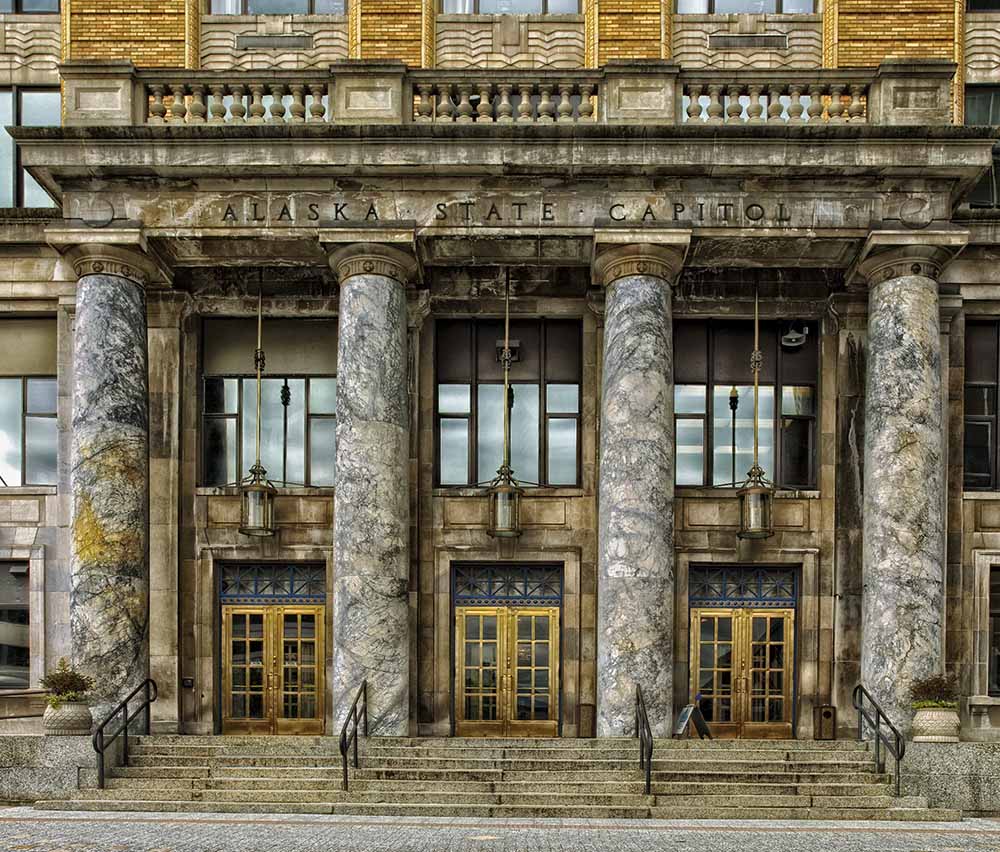 four marble gold pillars in front of a building entrance