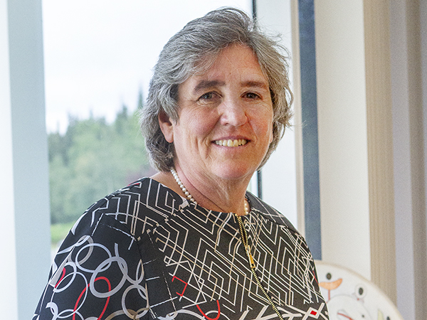 a short haired woman, president pitney, smiles at the camera