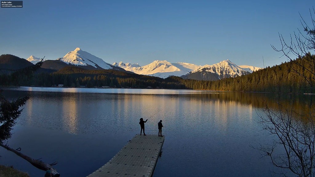 People silhouetted against Auke Lake and a mountain backdrop