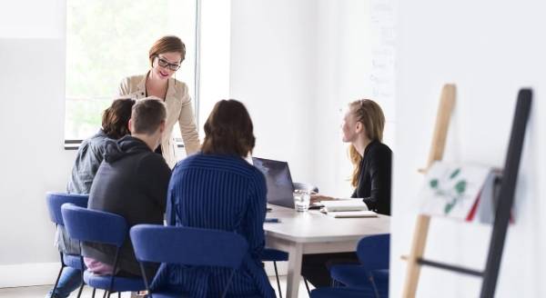 Faculty member addressing students seated at a table