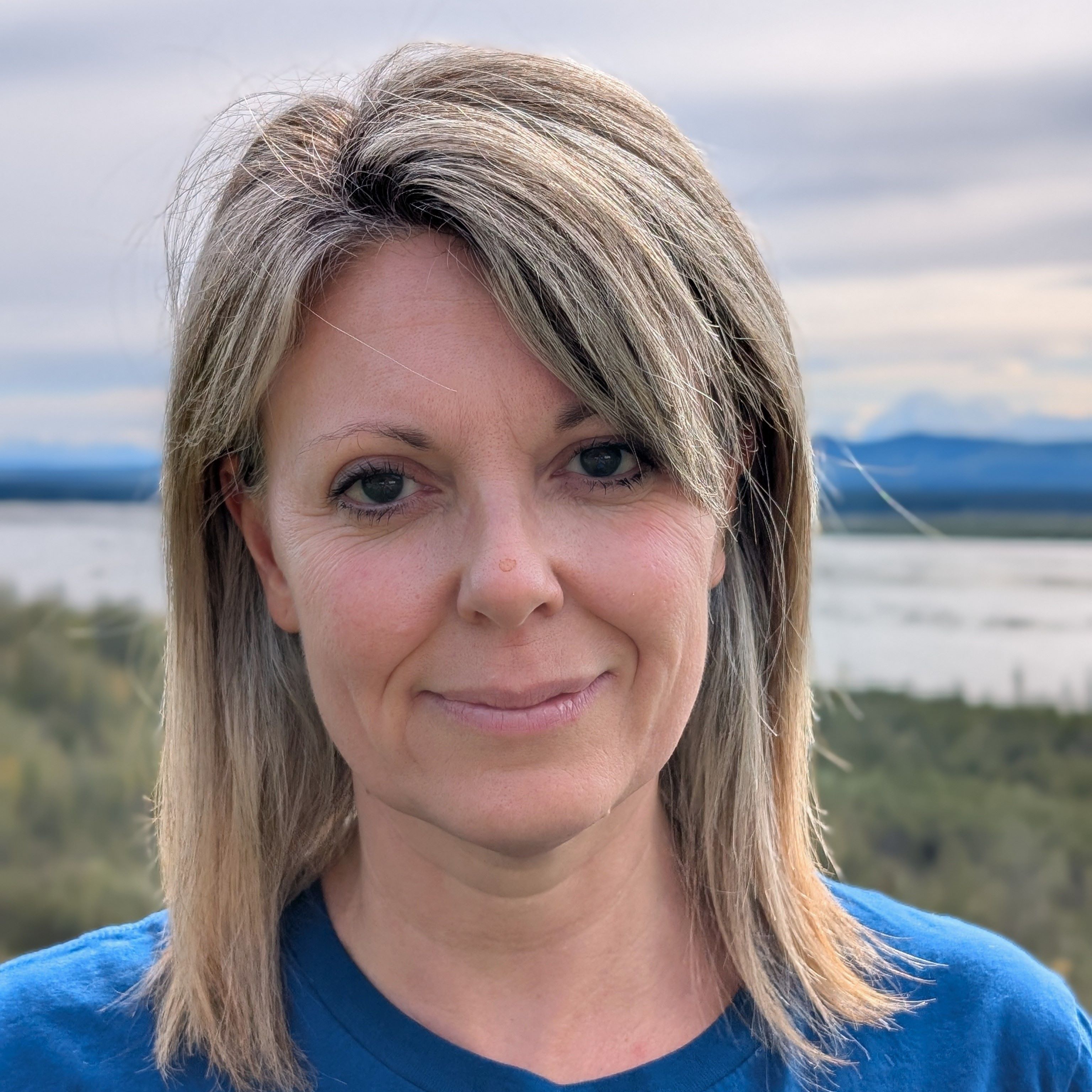 Anna Costa outdoor portrait, with river and mountains in the background