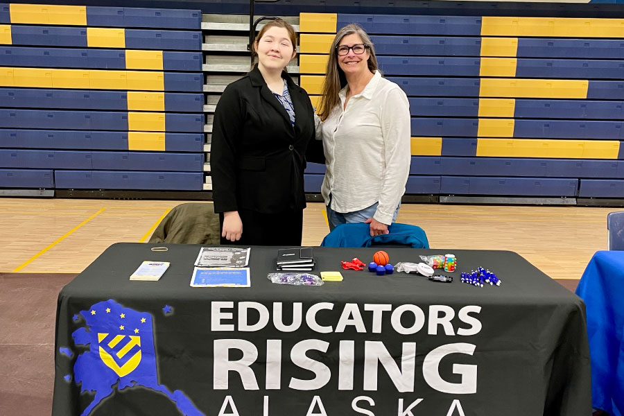 Two peope behind an Educator Rising Alaska table