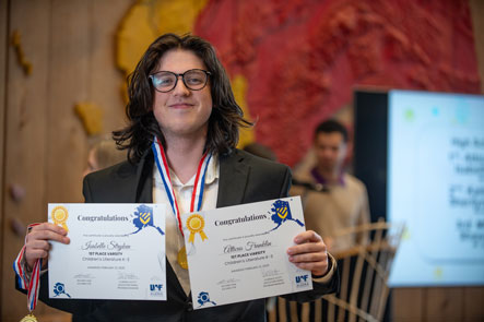 A student at Educators Rising Alaska Statewide Leadership Competition holds up their award certificates