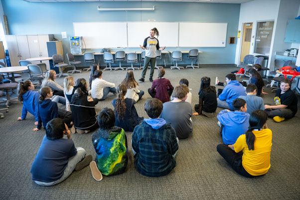 A Teacher Leader stands before children in a classroom