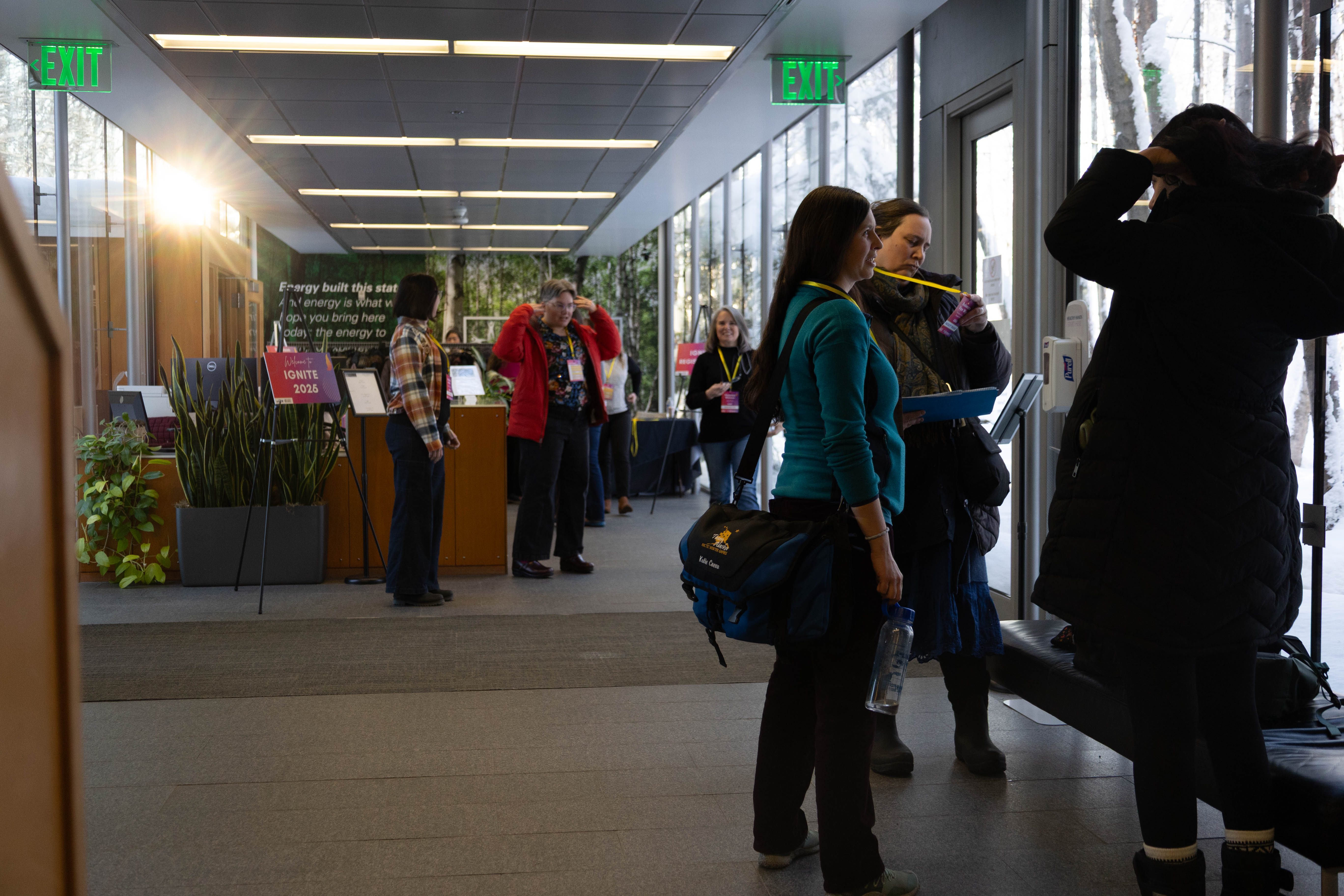 IGNITE attendees mingling in the sunlit hallway before lunch.