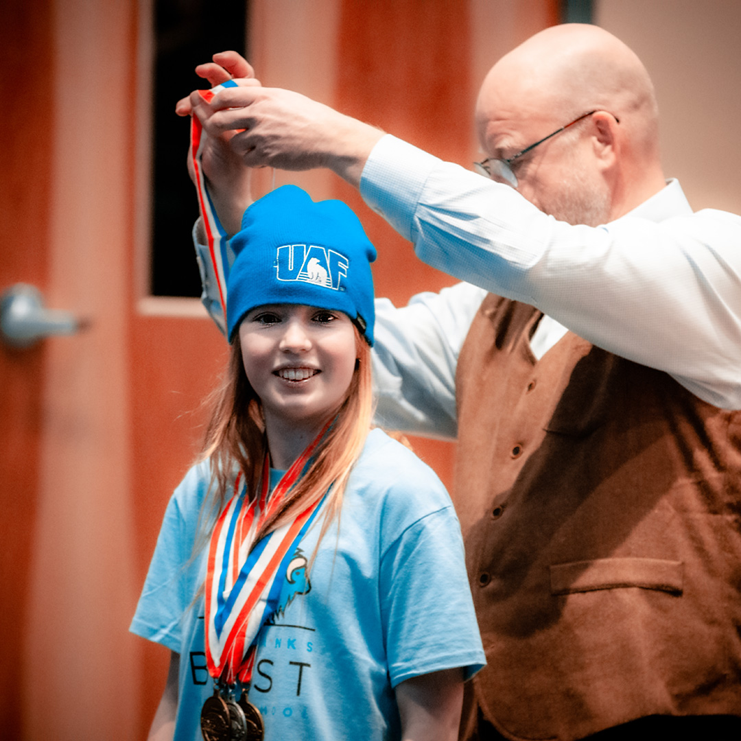 Girl receives award at Science Olympiad