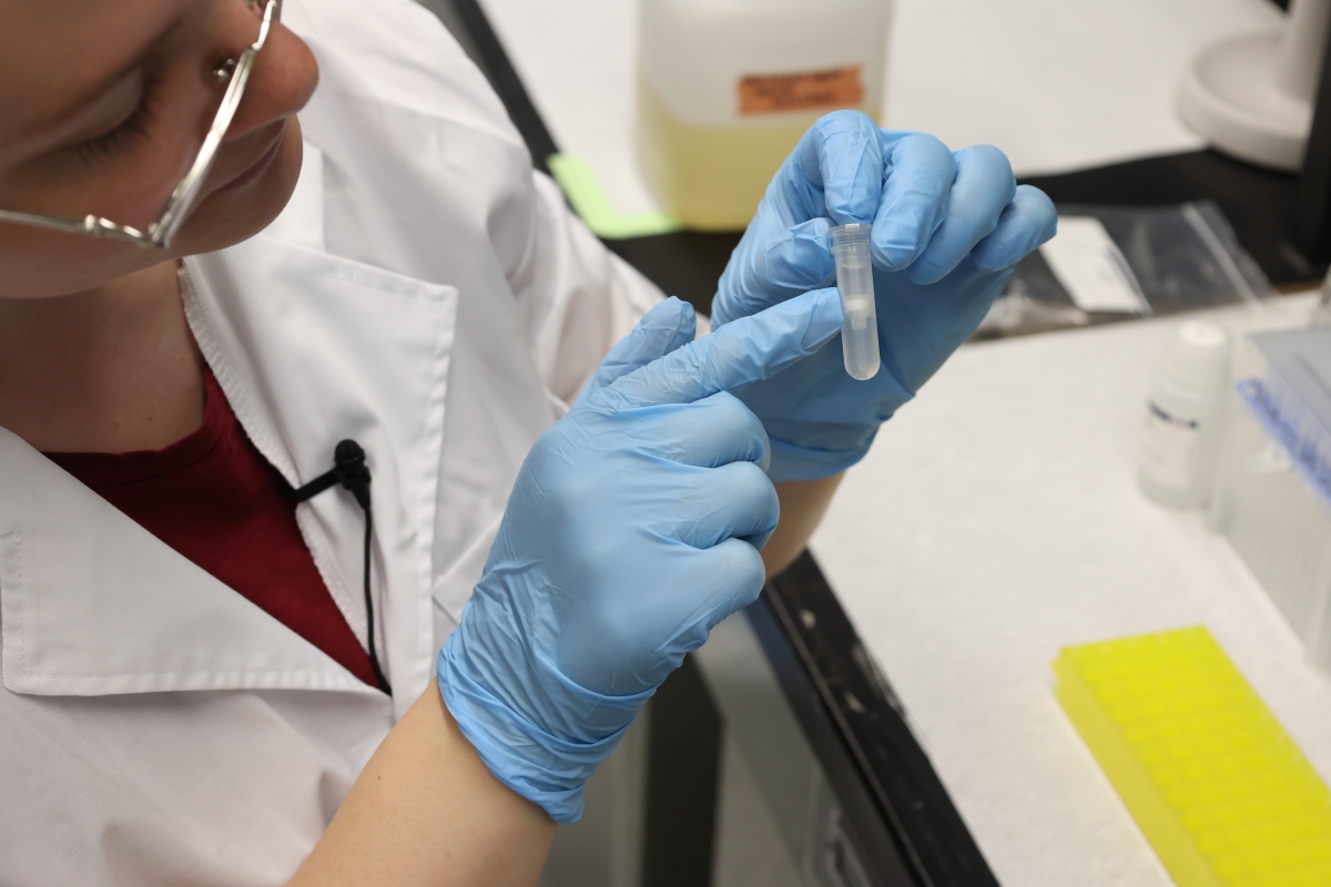 A student points to a small eDNA vial.