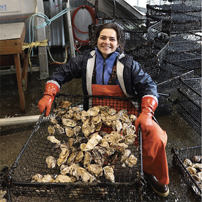Student holding a basket of oysters