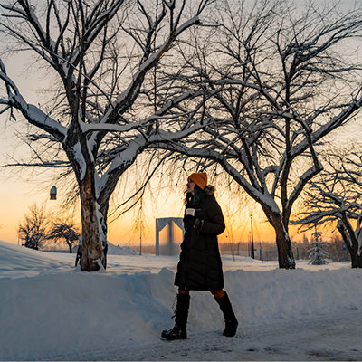 Student outdoors walking in winter sunset