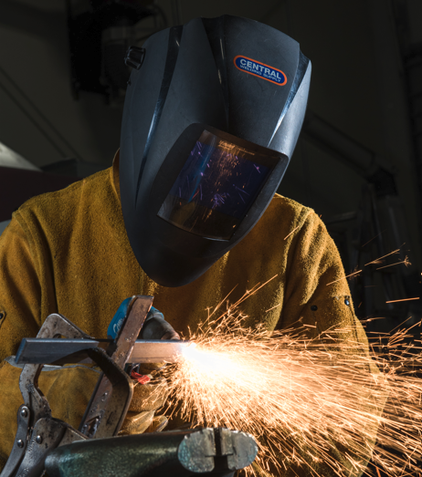 Photo of a student in a helmet welding