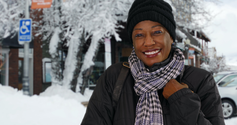 A retiree age woman in a snowing outdoor scene