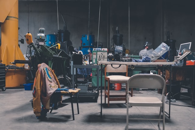 Shop full of tools and a table with chairs in the middle.