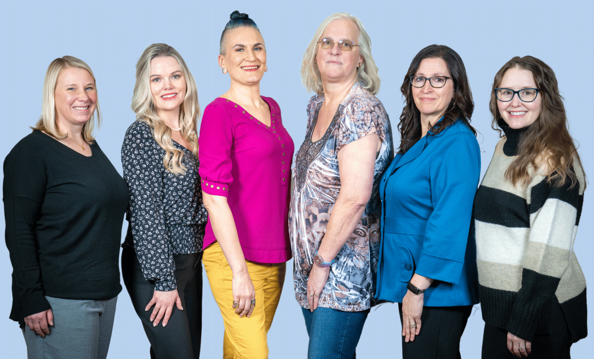 Five women standing together, all facing slightly inward