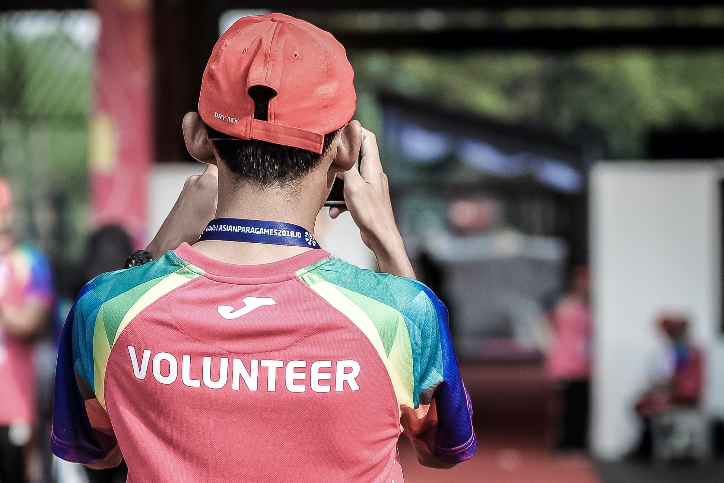 Person with short hair facing away from the viewer, shirt says volunteer on it.