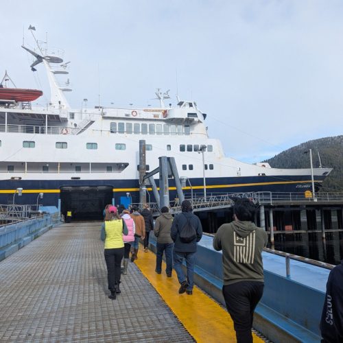 Students walk aboard a ferry terminal