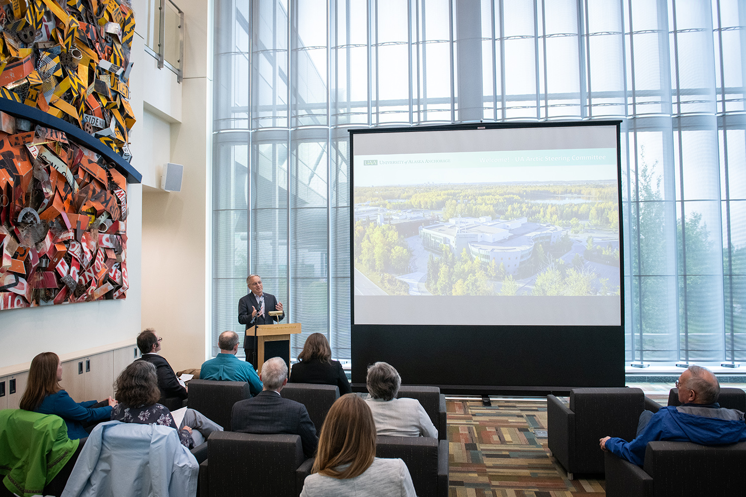 UAA Chancellor Sean Parnell gives remarks behind a podium to a crowd