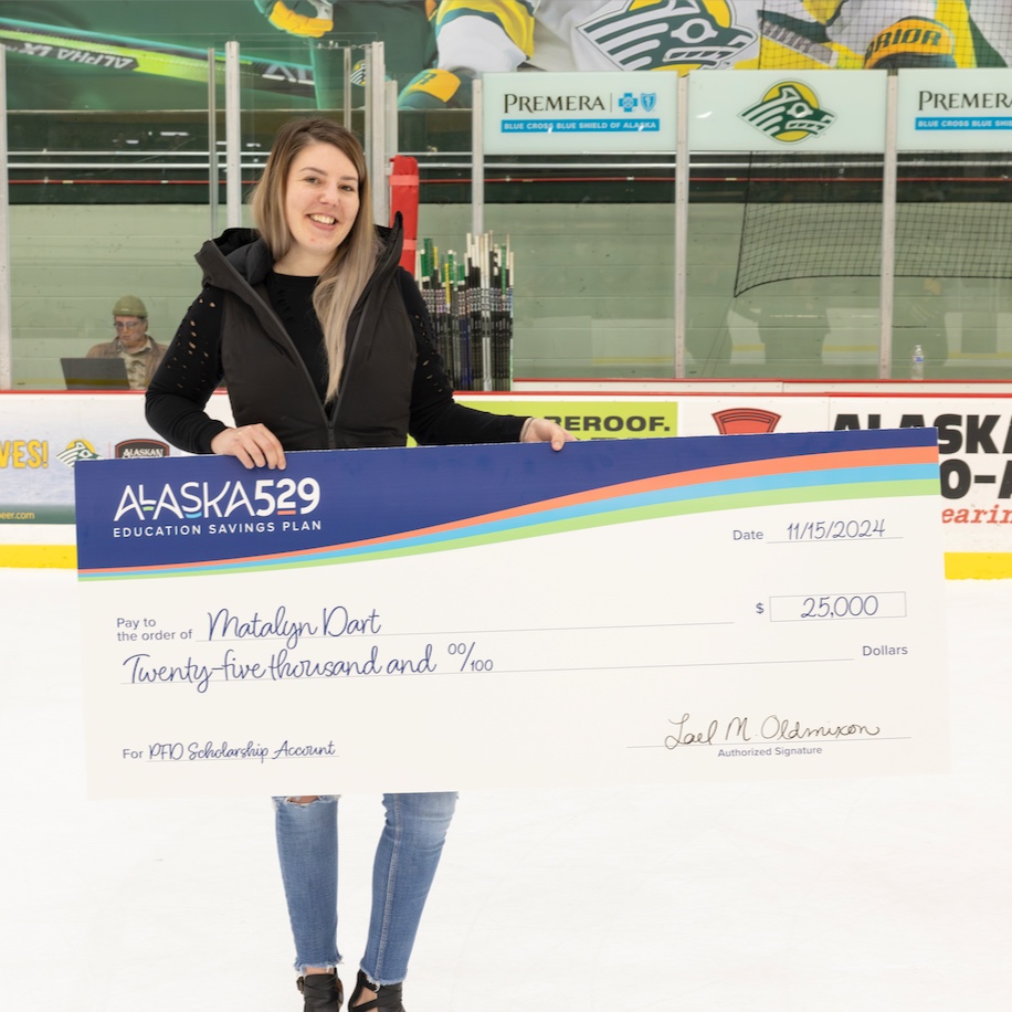 Matalyn Dart, the winner, poses with her large check on the hockey ice arena
