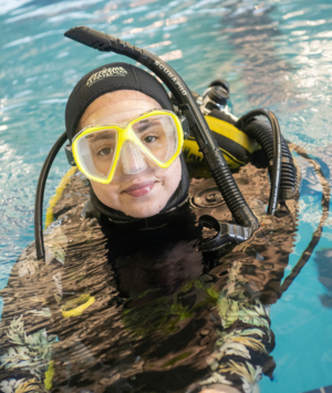 A student in a pool wears full scuba gear and face mask
