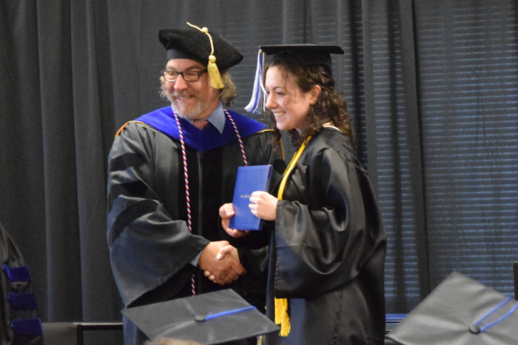 Kachemak Bay Campus Director Dr. Reid Brewer (left) presents valedictorian Elizabeth Rozeboom (right) with her Associate of Arts diploma during the 2023 KBC Commencement on Wednesday, May 10, 2023 in Homer, Alaska.