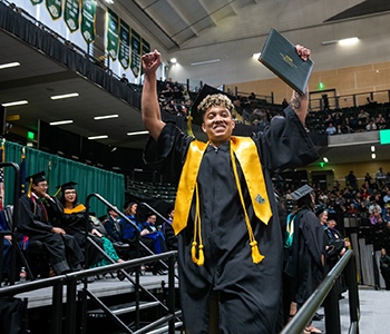 A UAA graduate celebrates after receiving his diploma