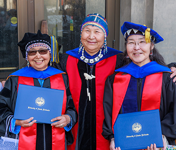Two Alaska Native PhD recipients take photo with a mentor