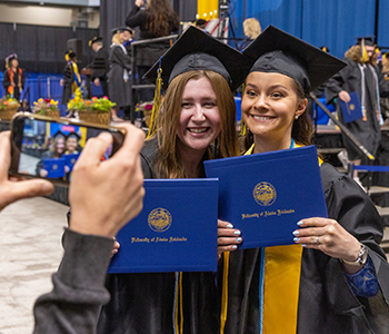 Two UAF graduates pose for a photo