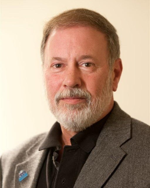 a man with short hair and brown blazer