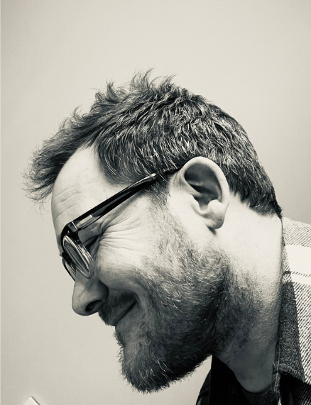 a man with a beard and glasses close up