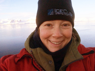 Winter portrait of Julie Schram with mountains and lake behind her