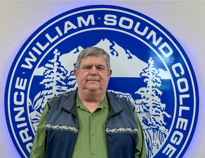A man stands in front of the PWSC sign