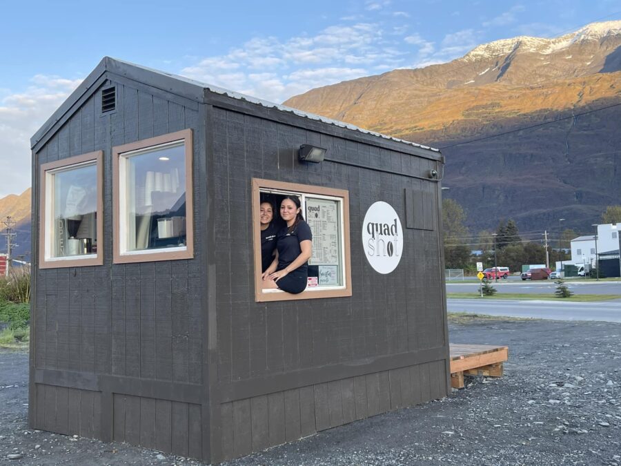 two daughter perched in the window of the hut