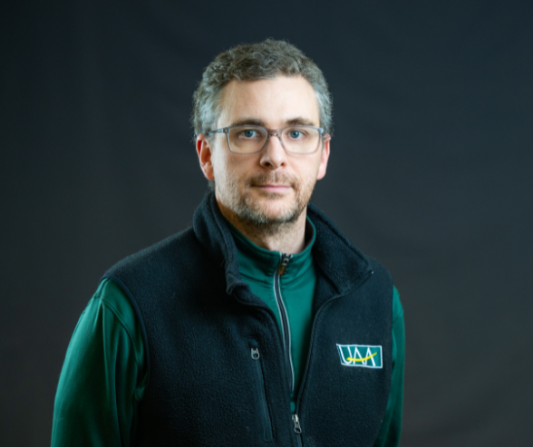a man with short grey hair wearing a UAA vest