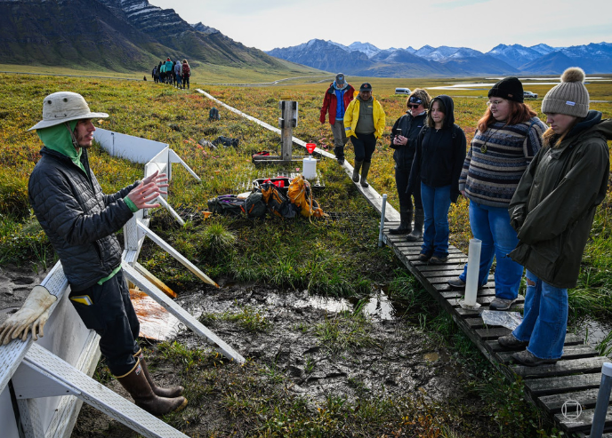 Graduate student Brandon Yokeley demonstrates a field sampling technique to a visiting high school field course near Galbraith Lake