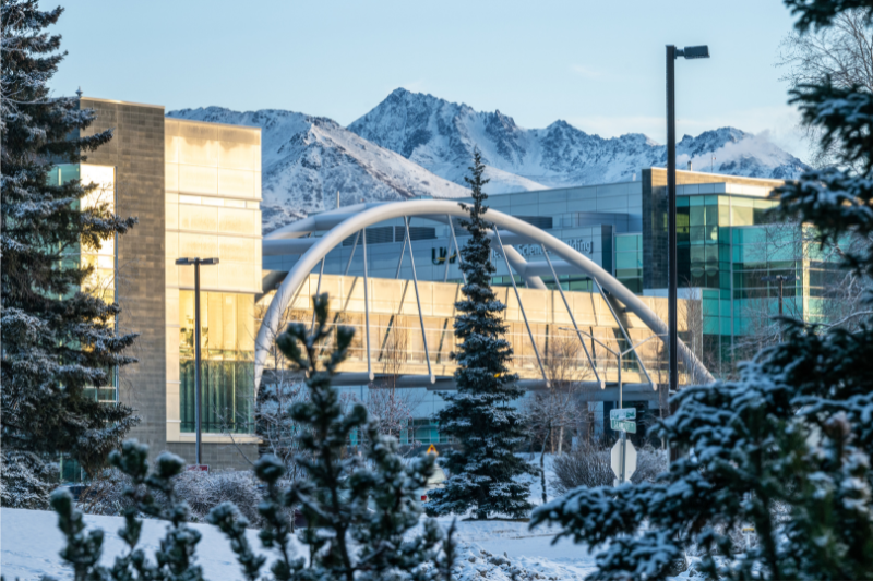 view of campus buildings in winter with mountains in background