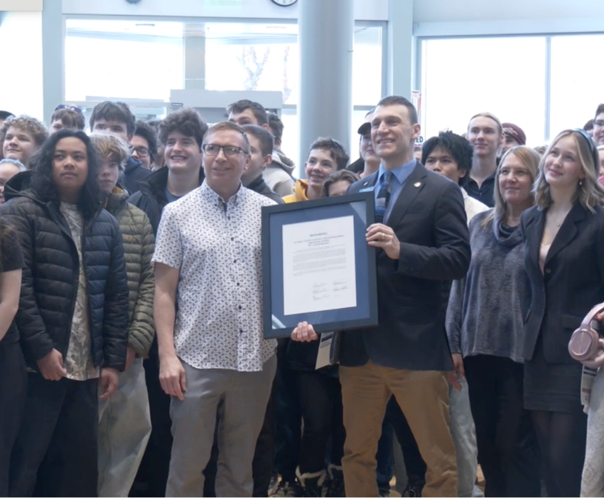 A group holds up a large framed photo