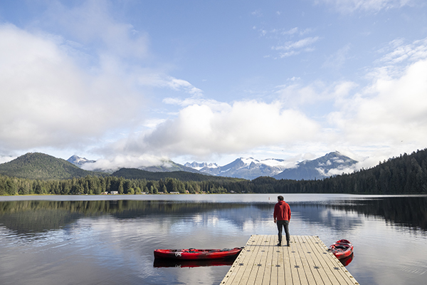 A person stands on a dock on Auke Lake in Juneau