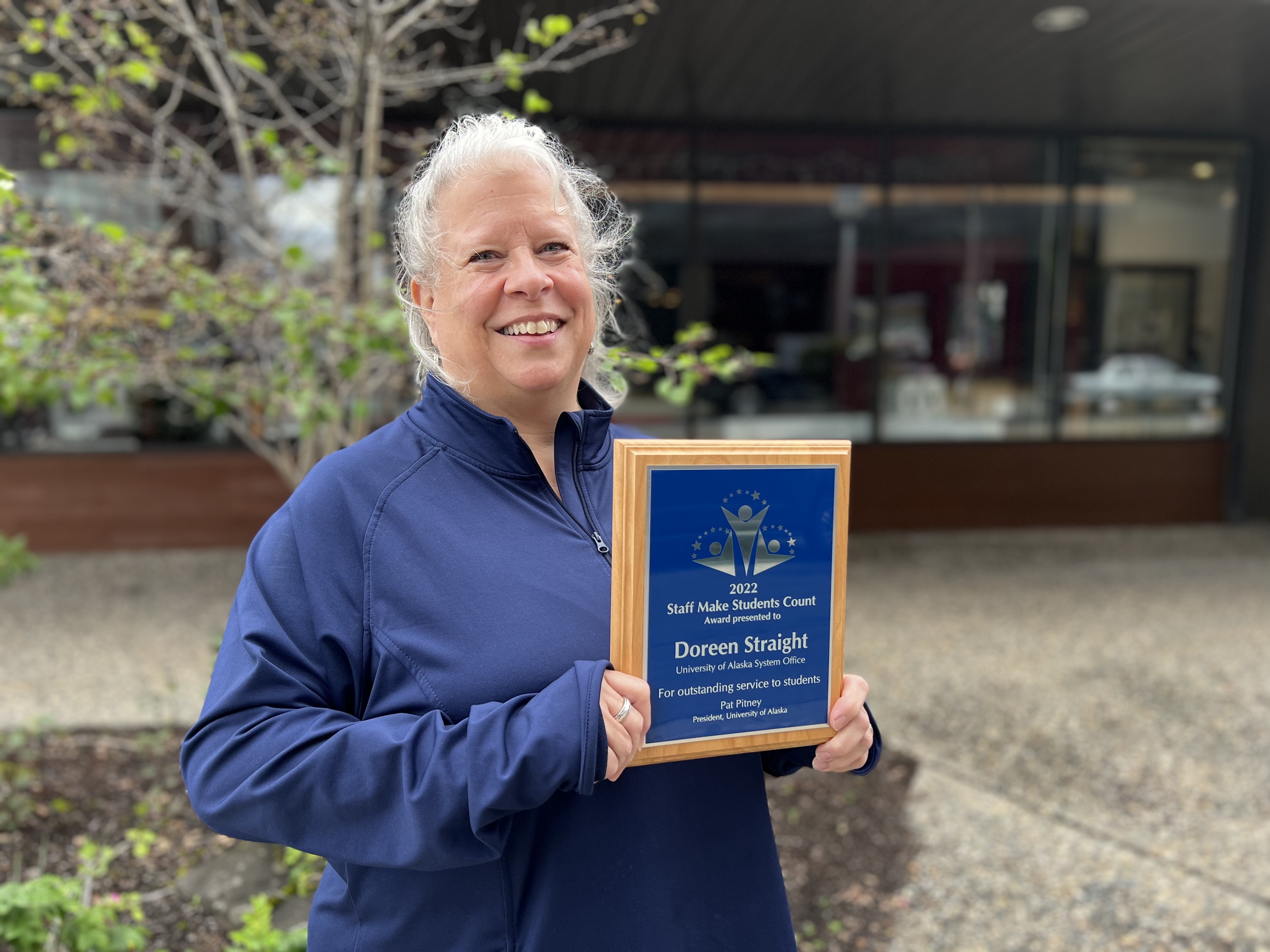 A previous winner holds up her plaque 