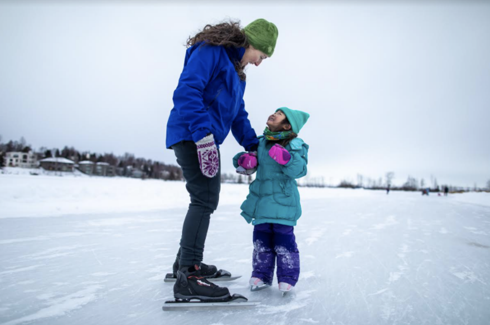 Mother and daughter ice skating outdoors