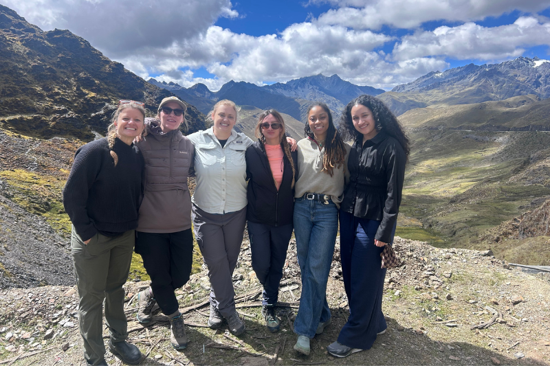 Participants in the Peru immersion program pose in a mountainous rural area of Peru during a cultural exchange visit.