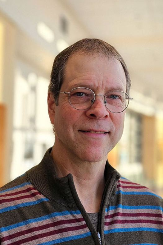 portrait of a man with glasses and striped shirt