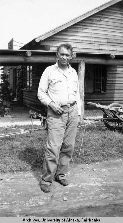 Slim Williams standing outside "the Alaska cabin"