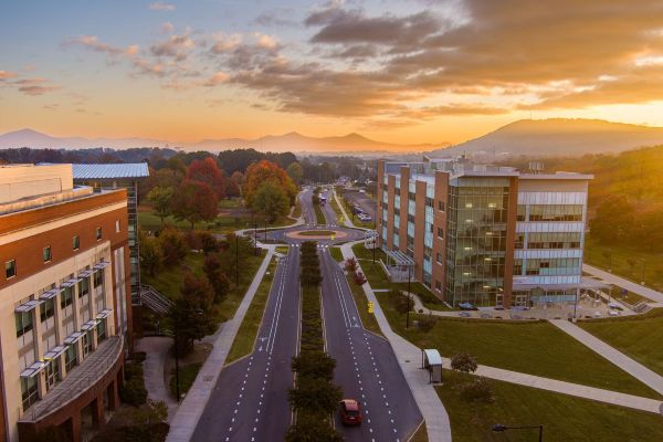 A skyline of buildings with small mountains in the background.