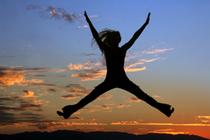 Woman jumping in the air at sunset