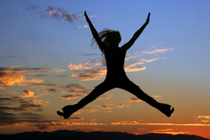 Person leaping in the air in front of a sunrise