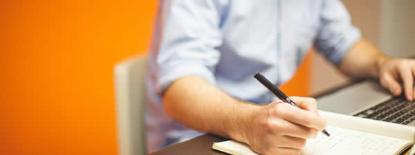 Generic picture of man writing in notebook.