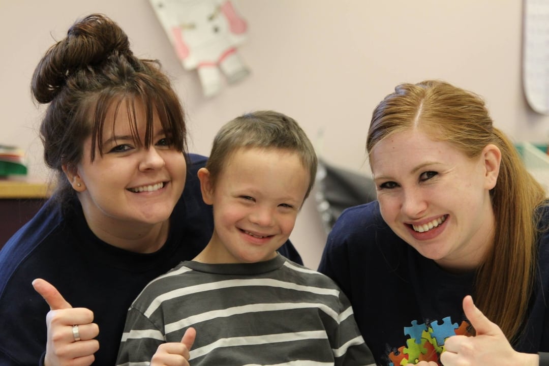 teachers and a student smiling