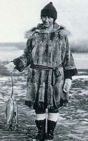 Mardy Murie in traditional Alaska Native clothing holding fish. Photo: Murie Collection